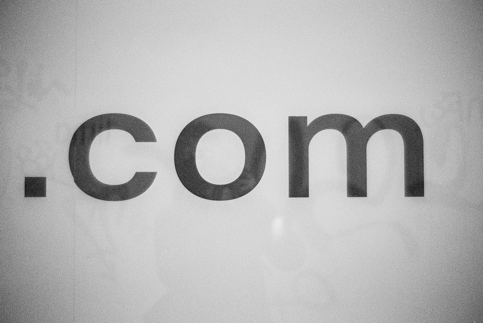 The image features the text '.com' in bold, black lettering against a plain white background. The text appears centered and the font is simple and modern.